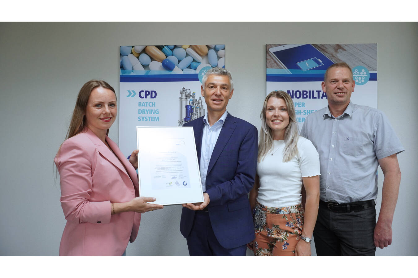 Minou Damen-Peeters, Sales Manager Industry beim TÜV Niederlande, überreicht Christophe Krug, CEO von Hosokawa Micron B.V., das ISO 14001-Zertifikat. Mit im Bild sind QSHE-Manager Bert Lasker und QSHE-Mitarbeiterin Eline Liebreks.